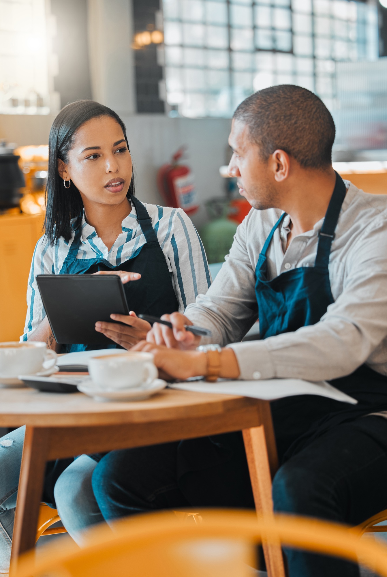 Startup, finance and coffee, cafe or small business owners at table with paperwork. Couple working