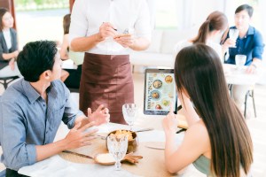 Laptop screen showing AI-driven restaurant analytics dashboard with graphs and charts.