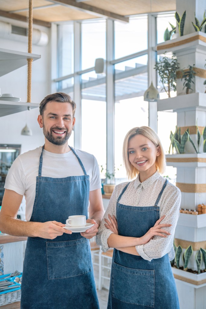 Restaurant manager reviewing AI-powered scheduling software on a laptop in the back office.