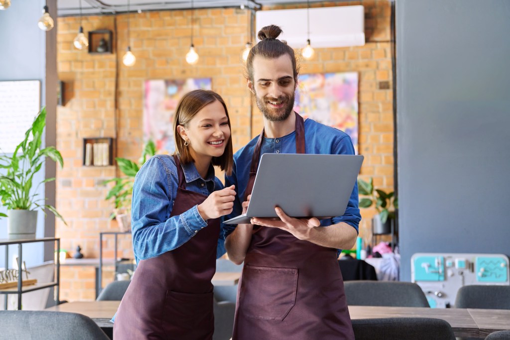 Restaurant manager using an AI-powered dashboard on a tablet to track labor and food costs.