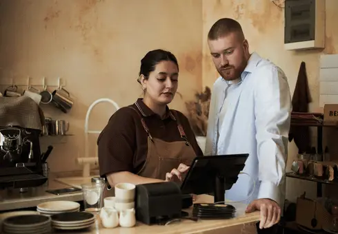Restaurant operator and TRIS consultant using a tablet to configure Restaurant365 system during kitchen operational setup